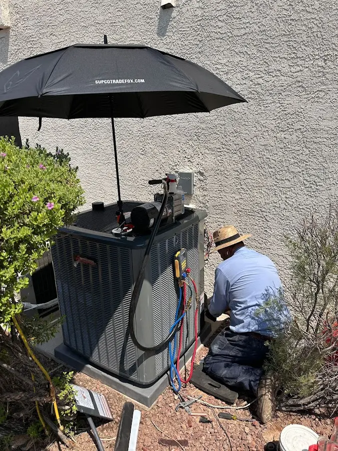 HVAC technician performing outdoor AC maintenance in Howard
