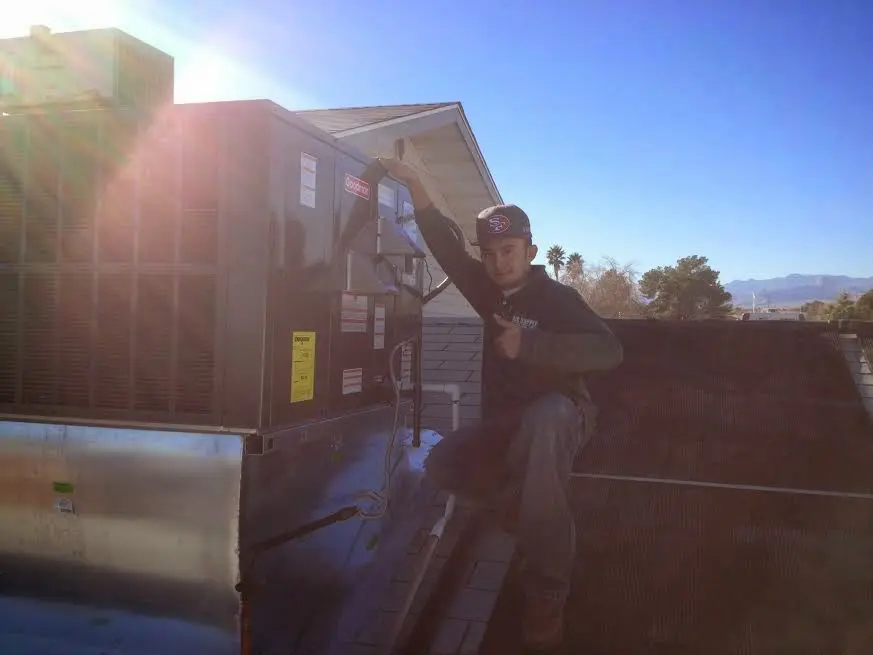 HVAC technician performing Heat Pump Repair on a rooftop unit in Howard